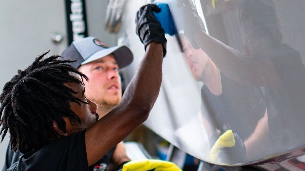 A man is polishing the side of an eagle premier rv