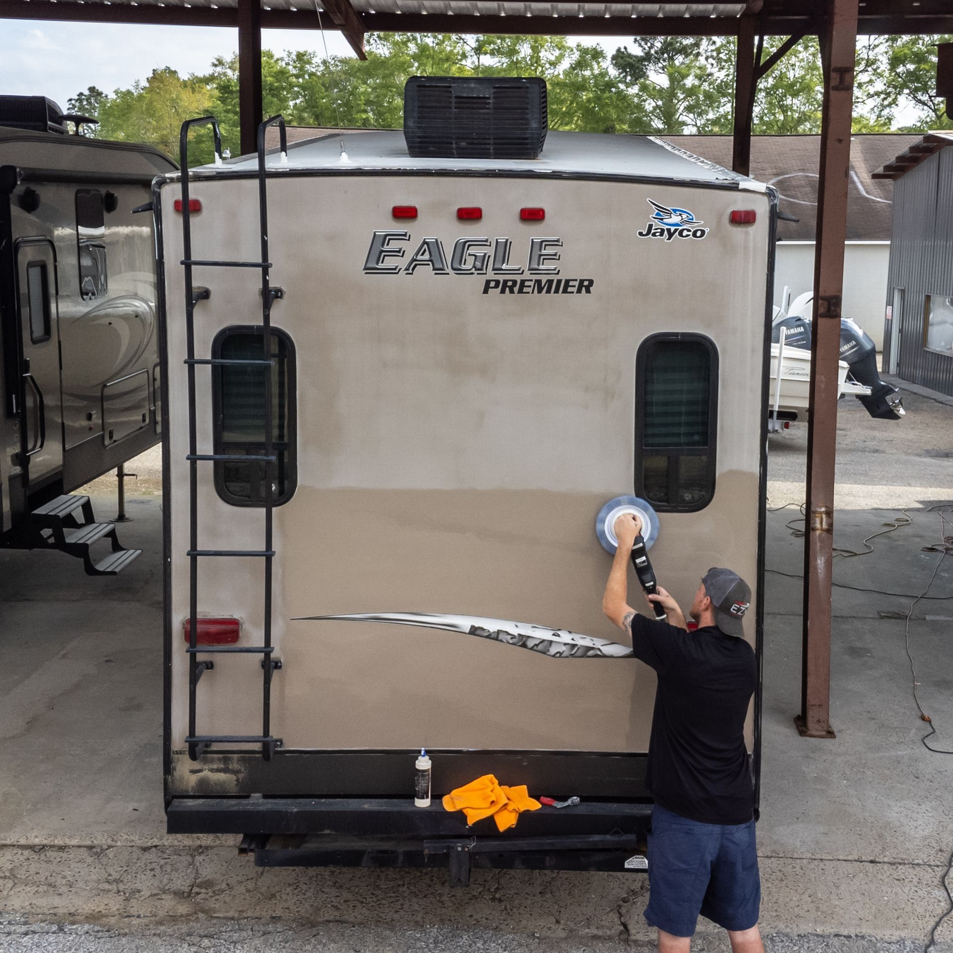 A man is polishing the side of an eagle premier rv