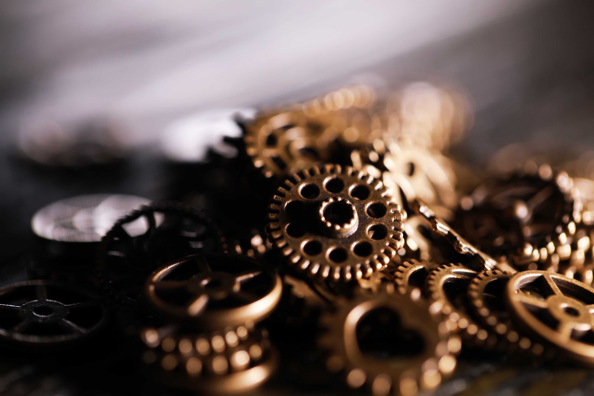 Gros plan sur des engrenages, des rouages ​​et autres pièces d'horlogerie dorés, certains d'une netteté remarquable.