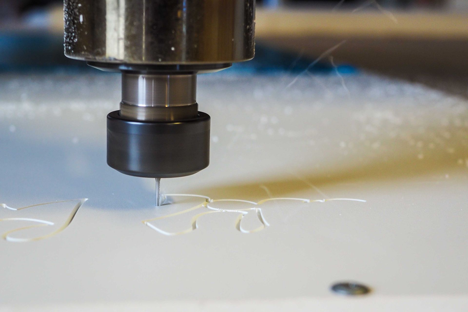 Machine CNC usinant un matériau blanc, produisant des copeaux.