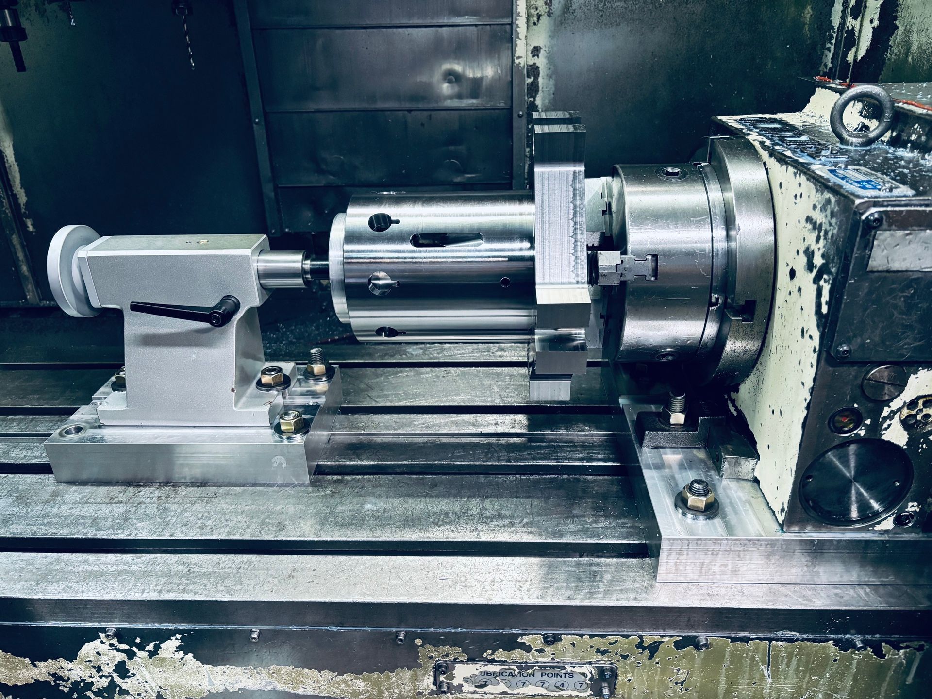 Une machine CNC avec une pièce à usiner entre un mandrin et une contre-pointe, pour les opérations d'usinage.