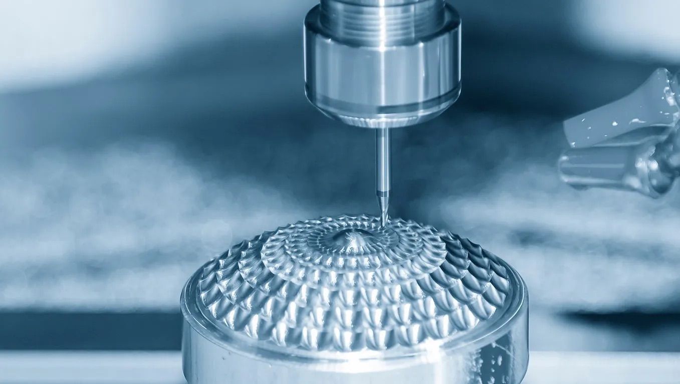 Usinage CNC d'une forme de dôme métallique détaillée à l'aide d'un outil de coupe.