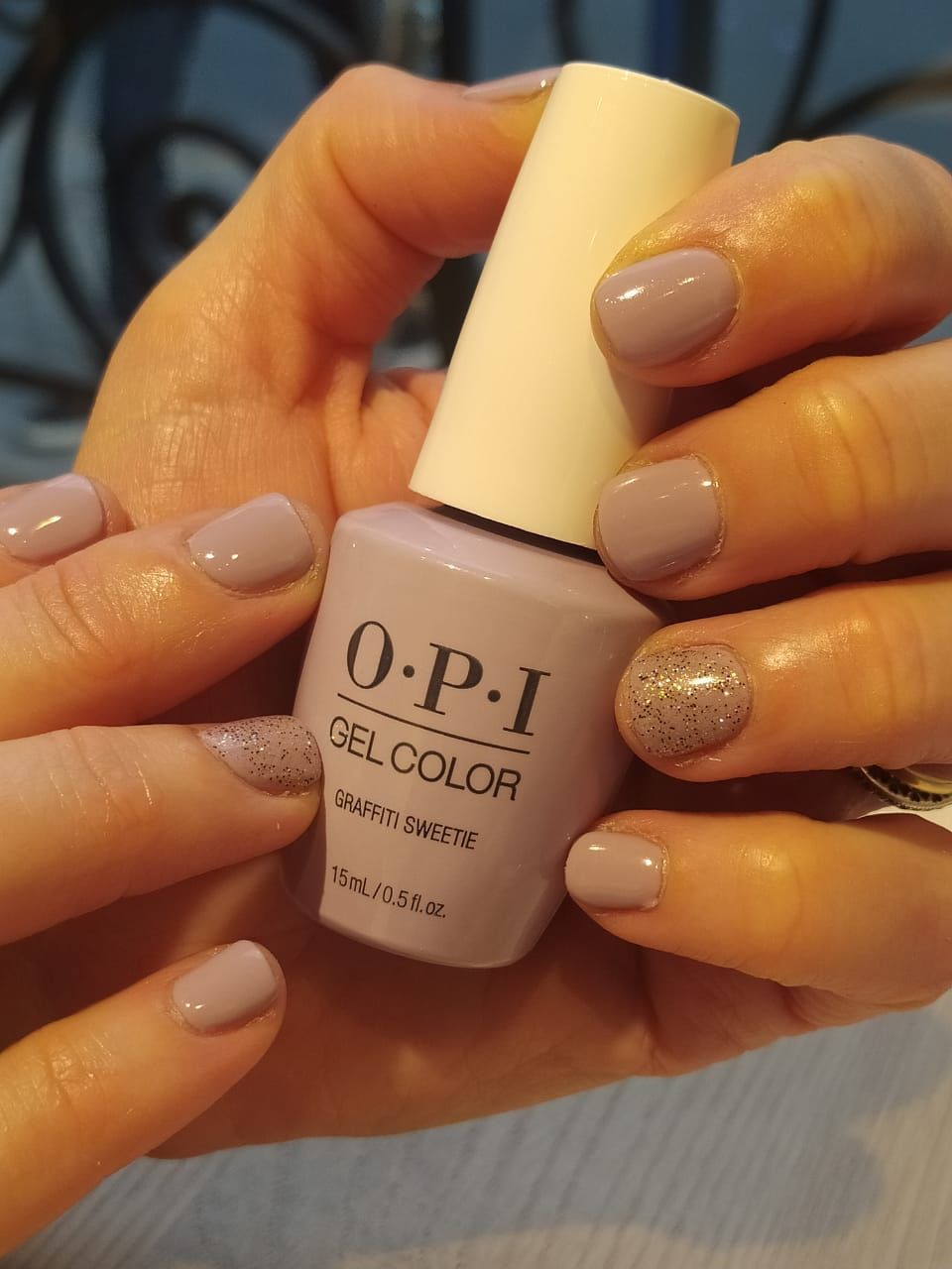 Una mujer sostiene un esmalte gel OPI.