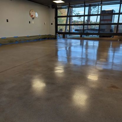 A large room with a concrete floor and a lot of windows.