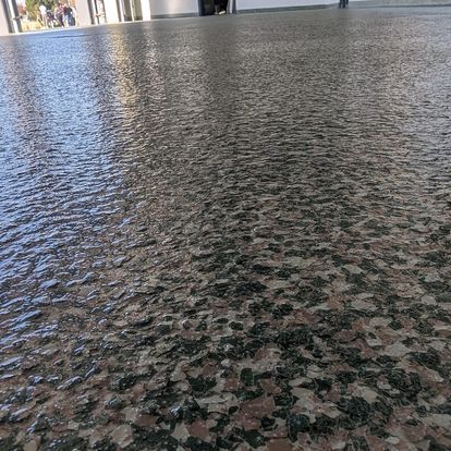A living room with a concrete floor and a fireplace.