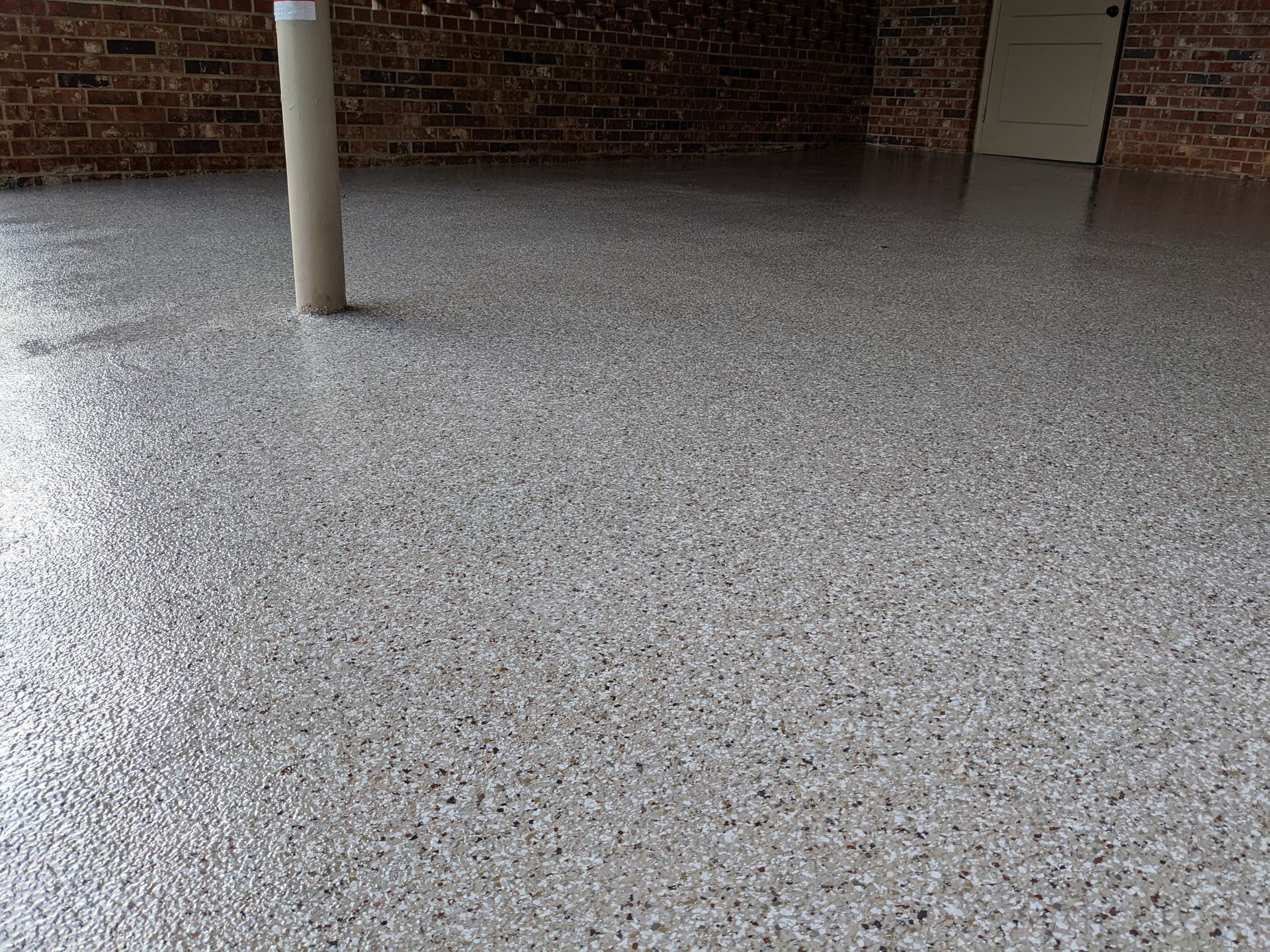 A garage floor with a brick wall in the background.