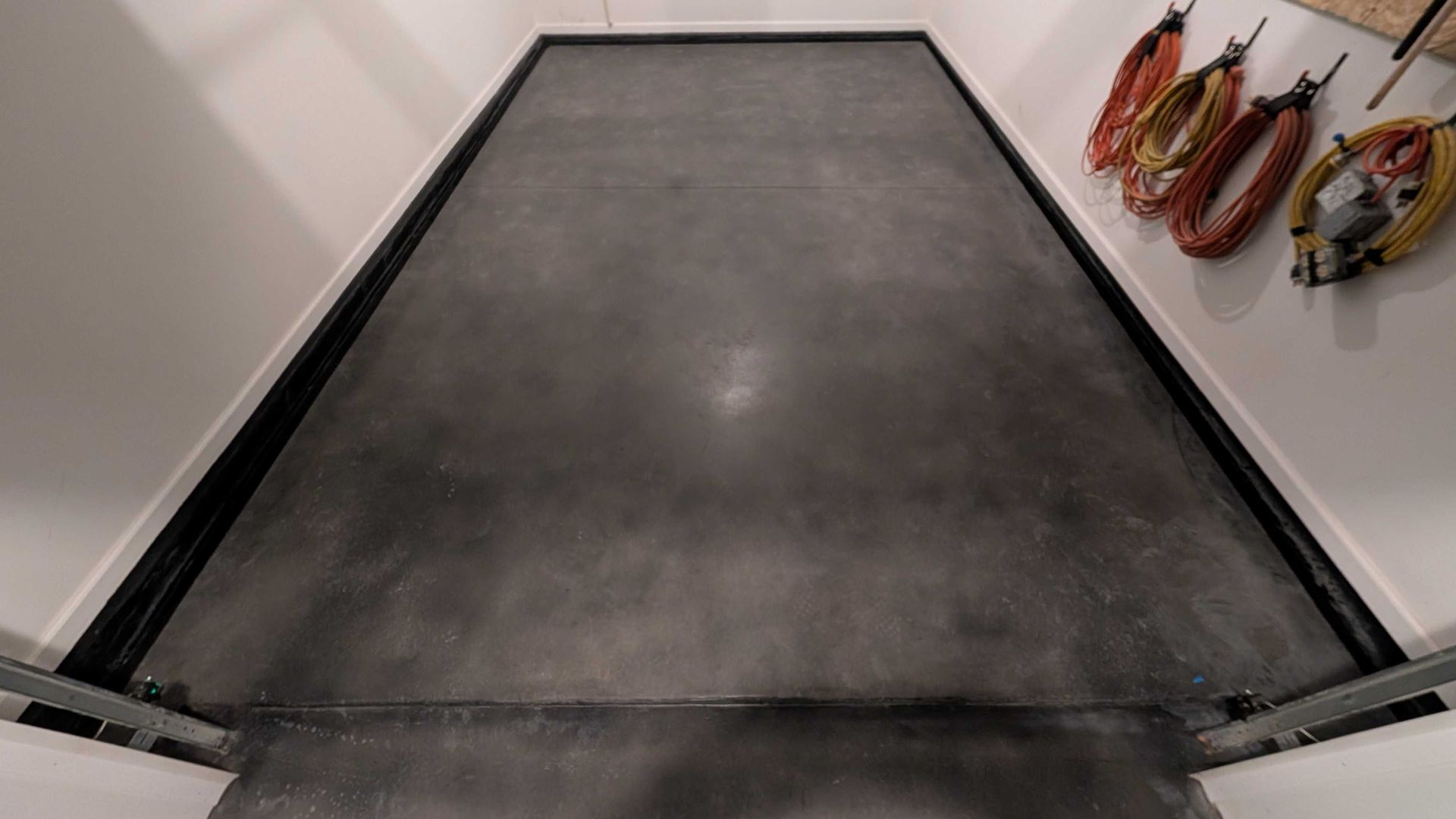 Smooth dark-stained concrete floor in Spartanburg garage with clean, even finish.