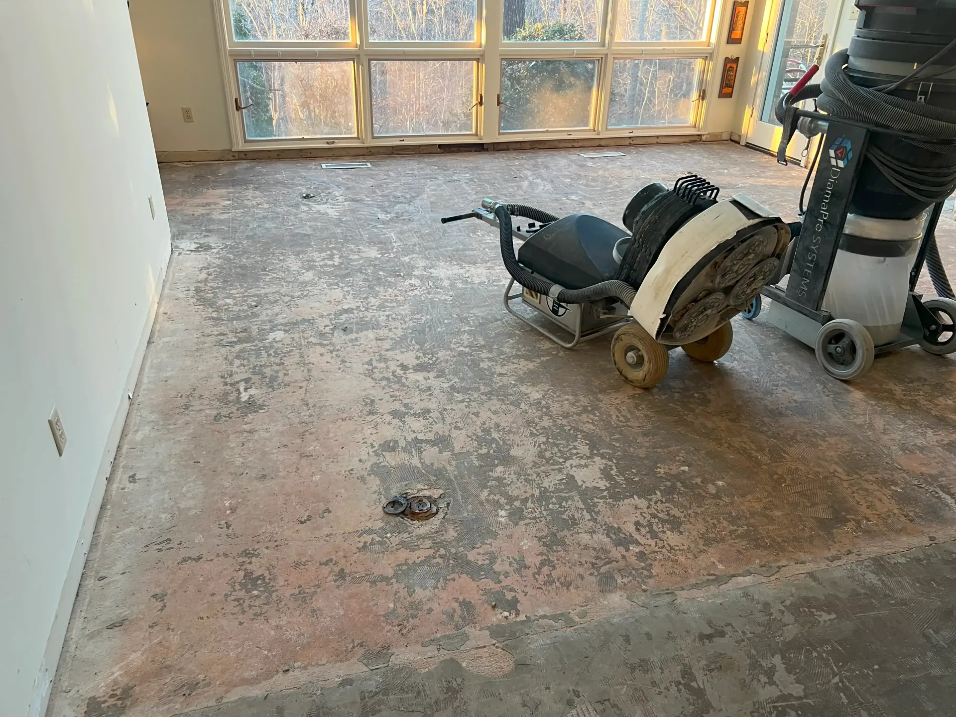 A living room with a concrete floor and a fireplace.