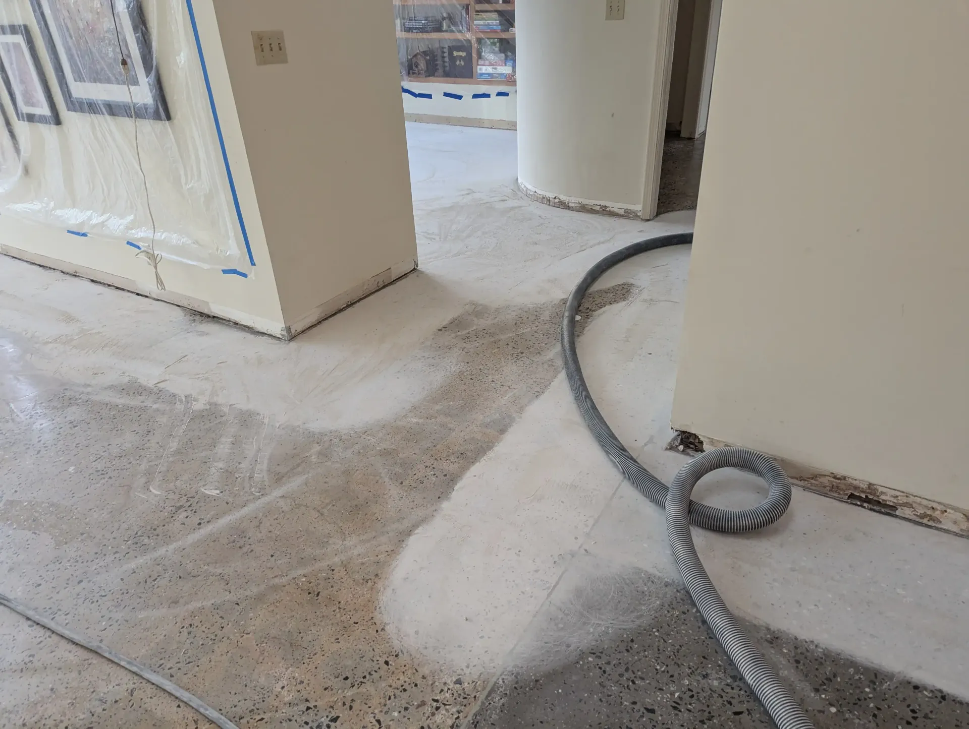 A concrete patio with a table and chairs in the background.