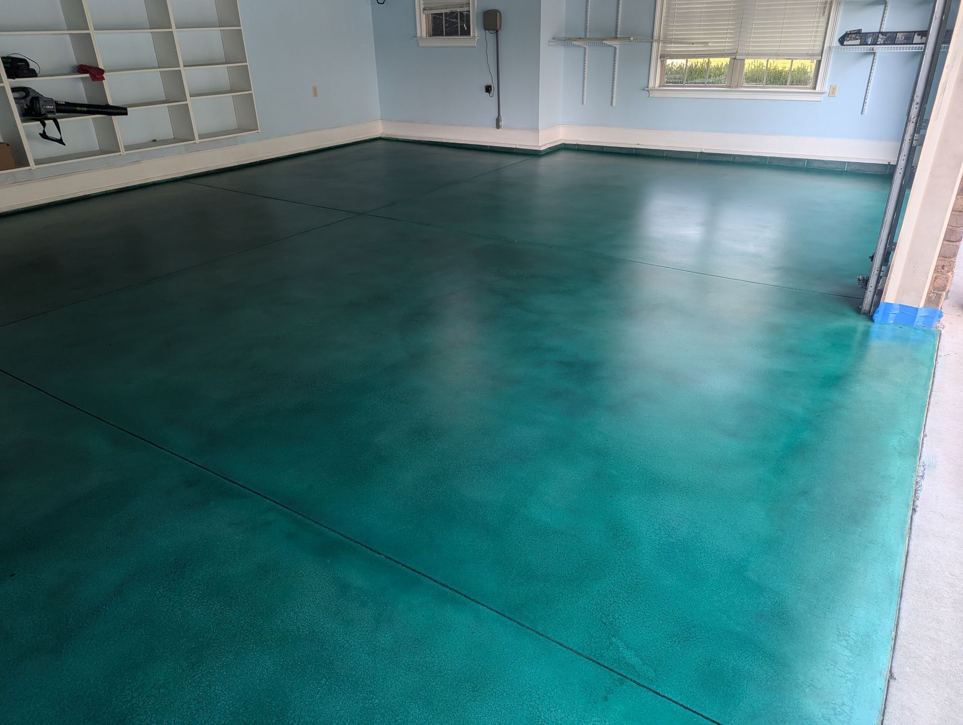 Stained turquoise concrete garage floor in Spartanburg with a smooth, custom finish.
