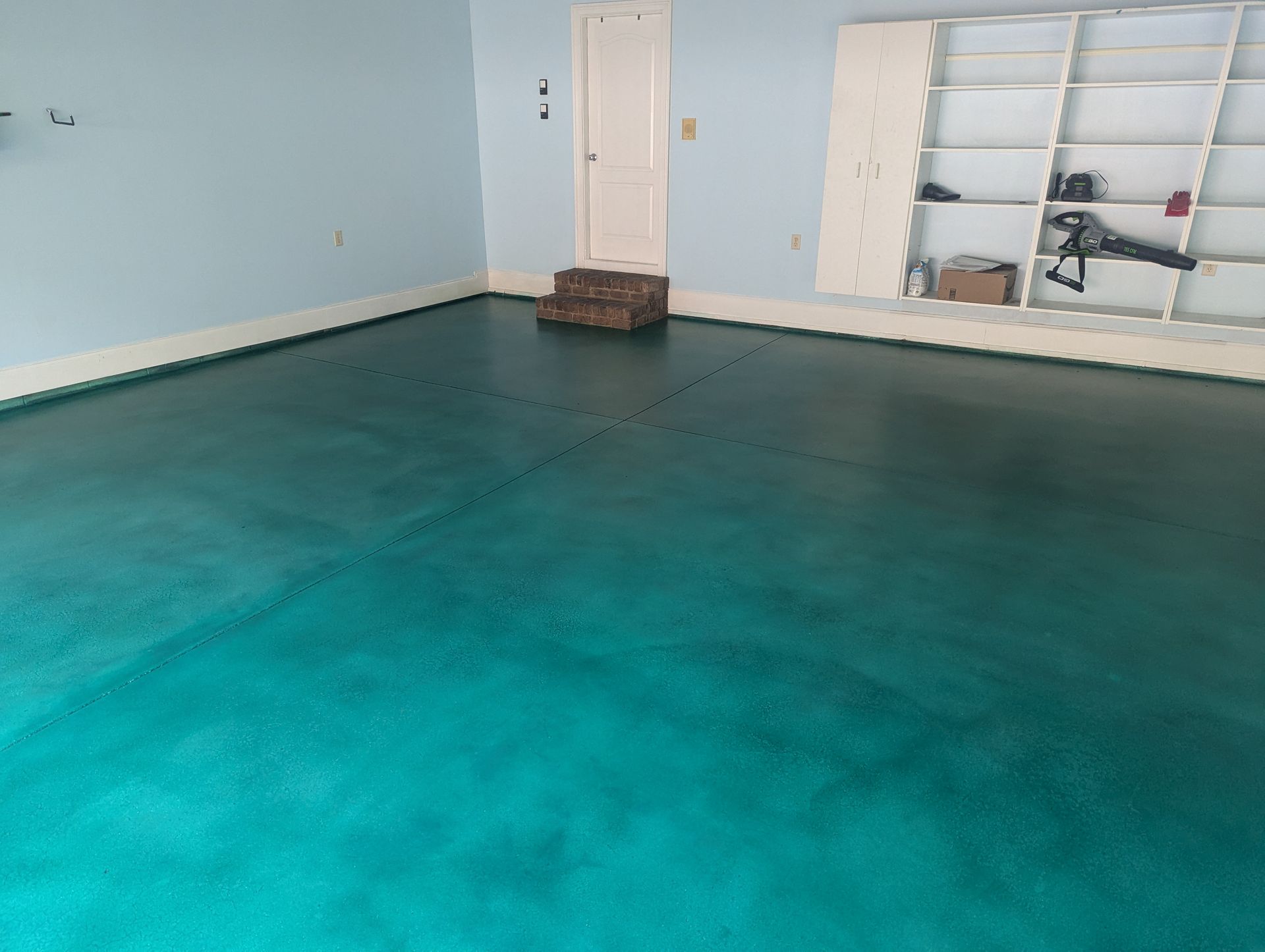 Stained turquoise concrete garage floor in Spartanburg with a smooth, custom finish.