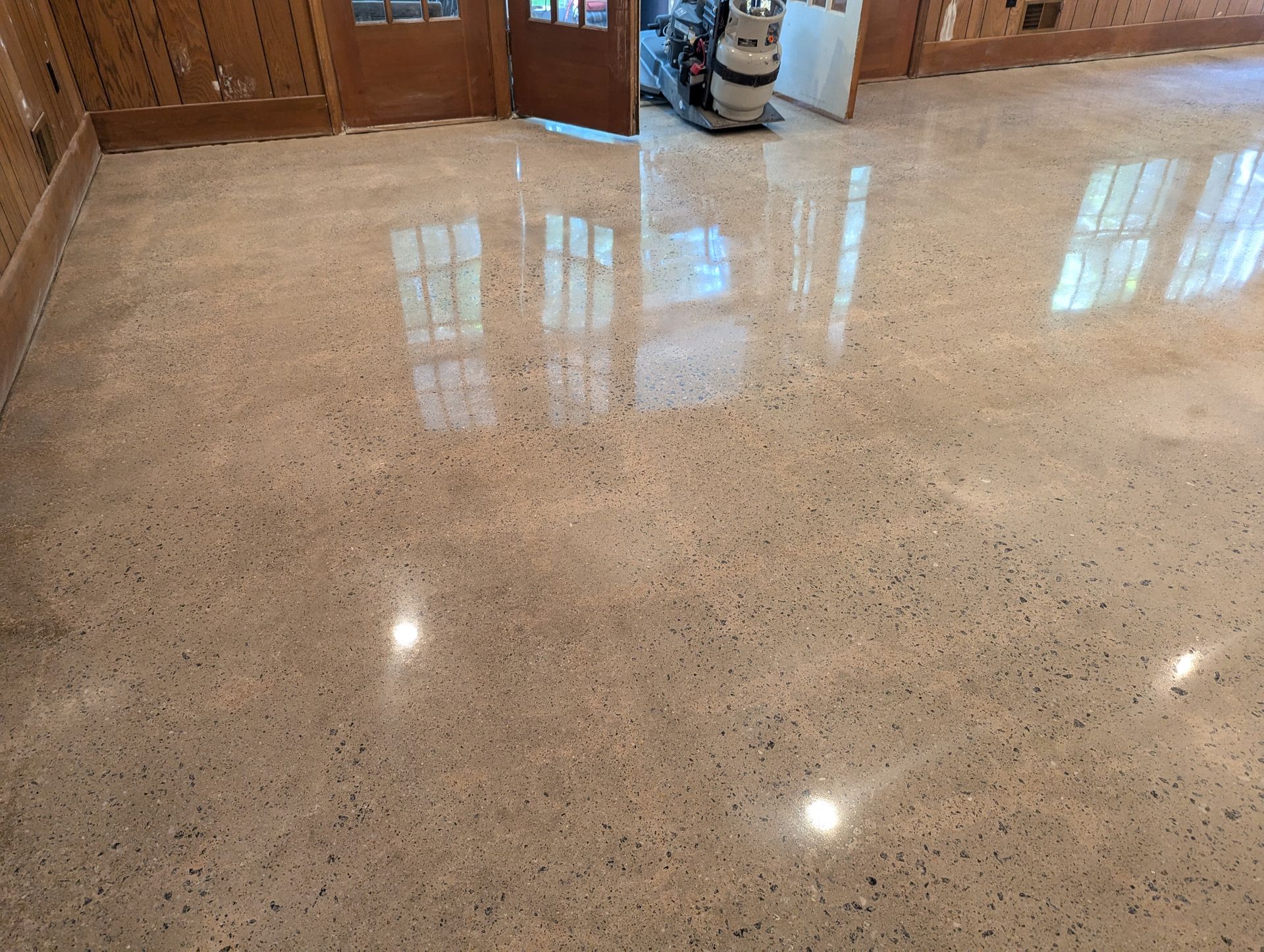 A shiny concrete floor with a vacuum cleaner on it.