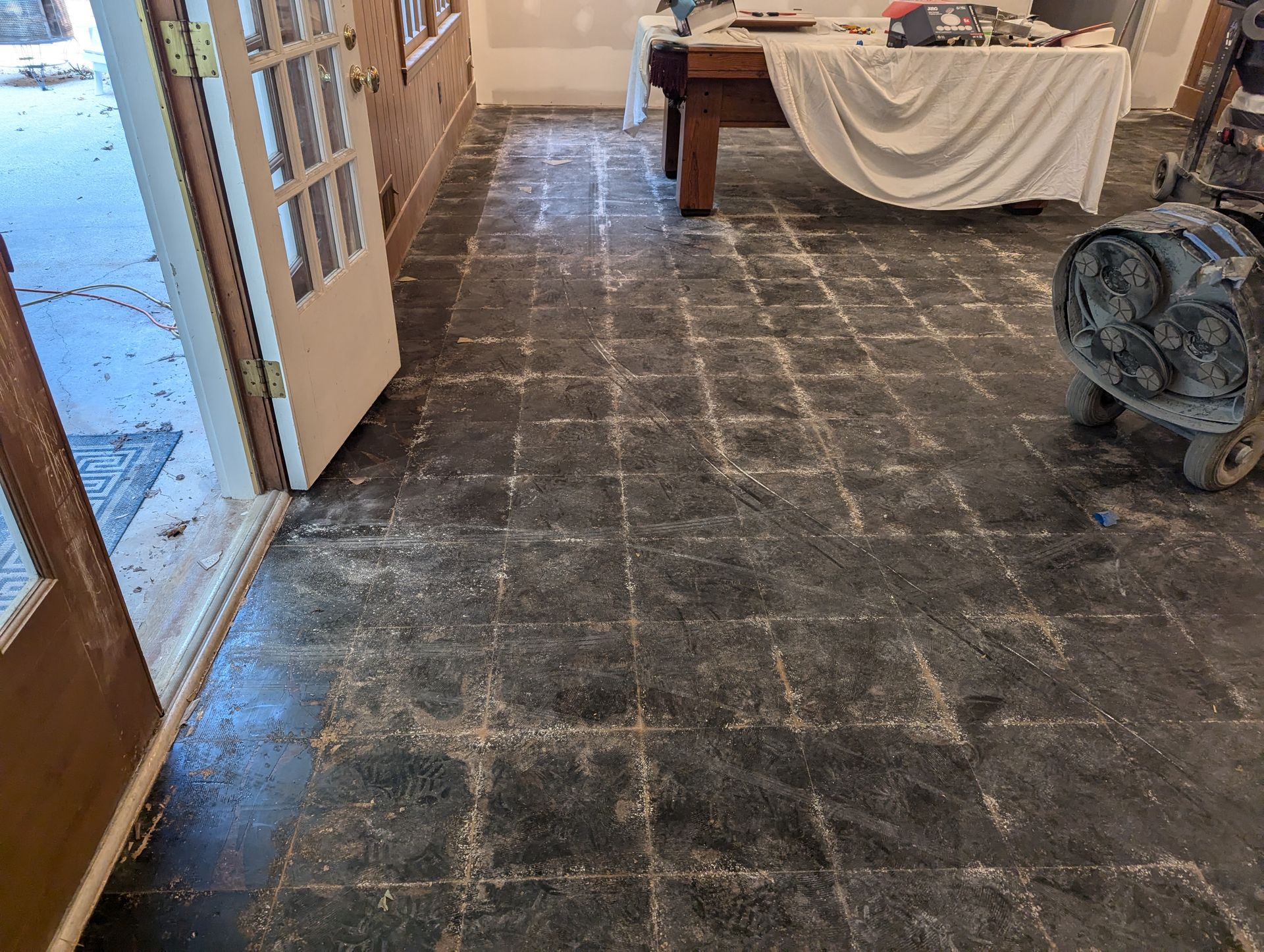 A room with a table and a vacuum cleaner on the floor.