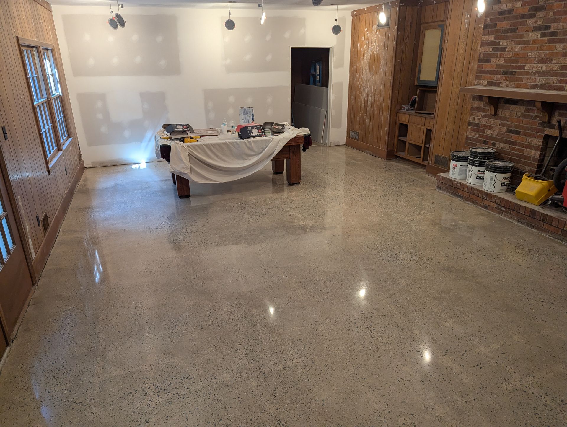 A large room with a concrete floor and a brick wall.