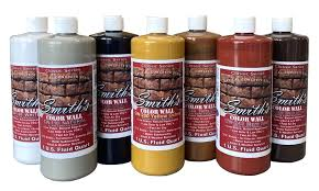 A group of bottles of paint are sitting next to each other on a table.