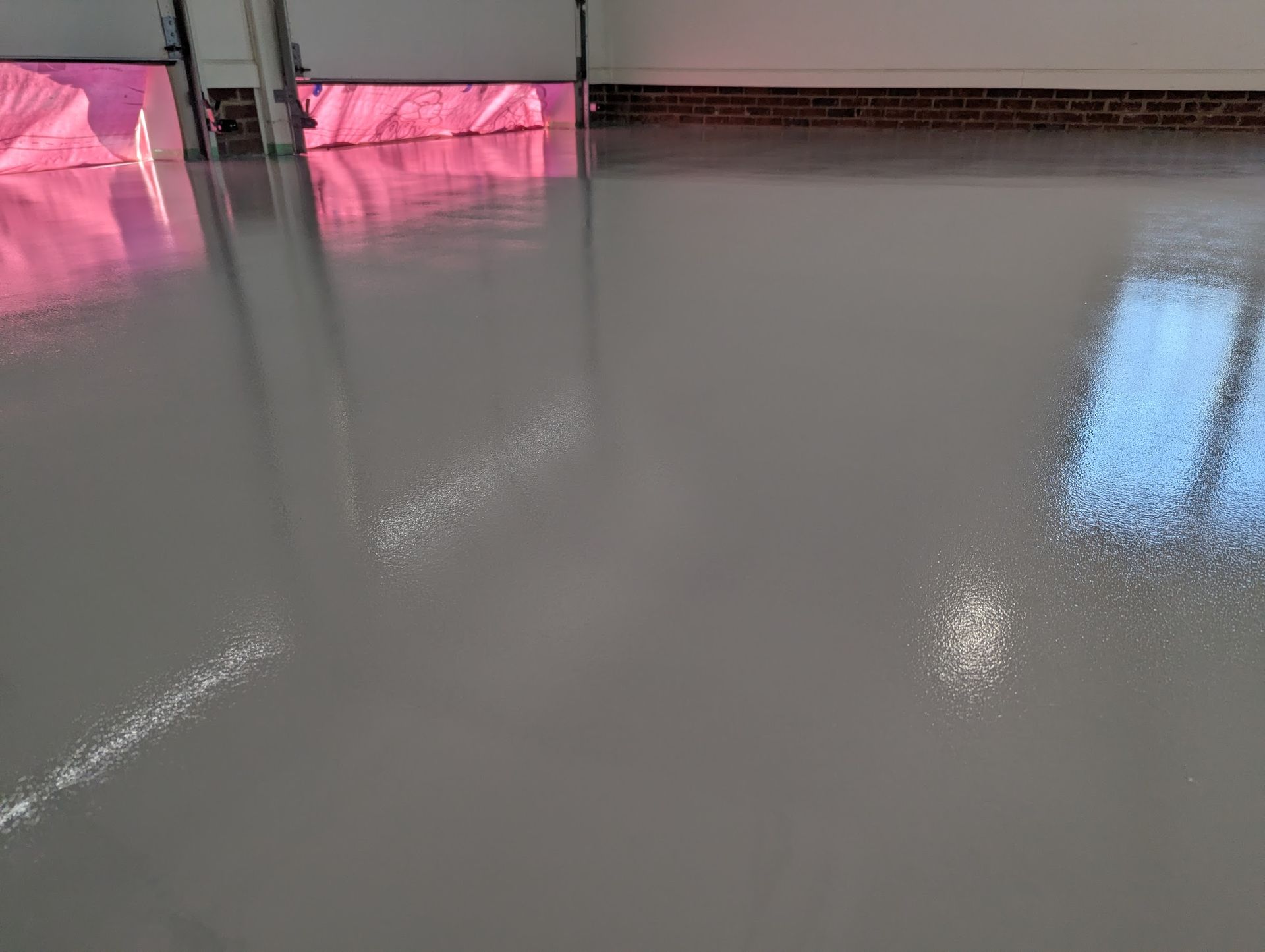 A close up of a shiny concrete floor with a reflection of lights.
