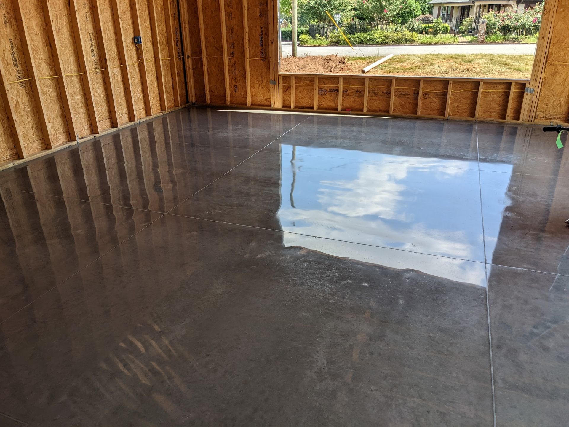 A shiny concrete floor in a room with a window.