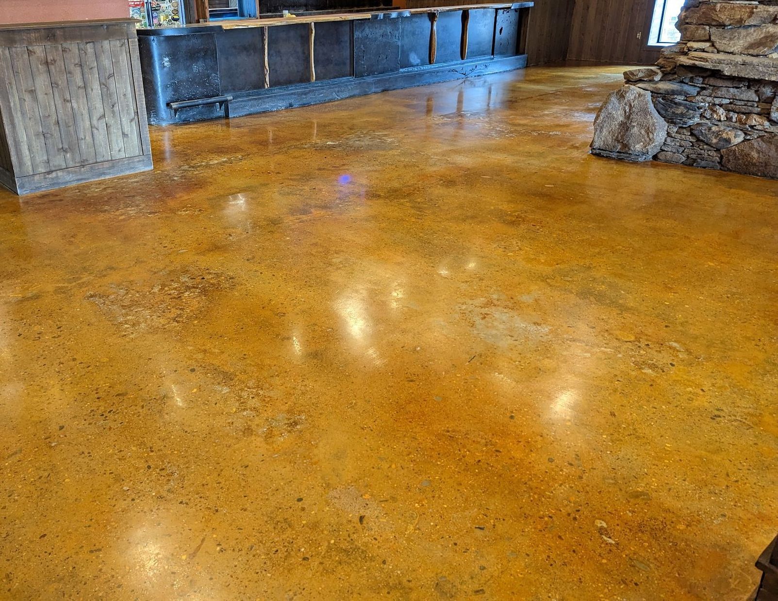 A living room with a concrete floor and a fireplace.