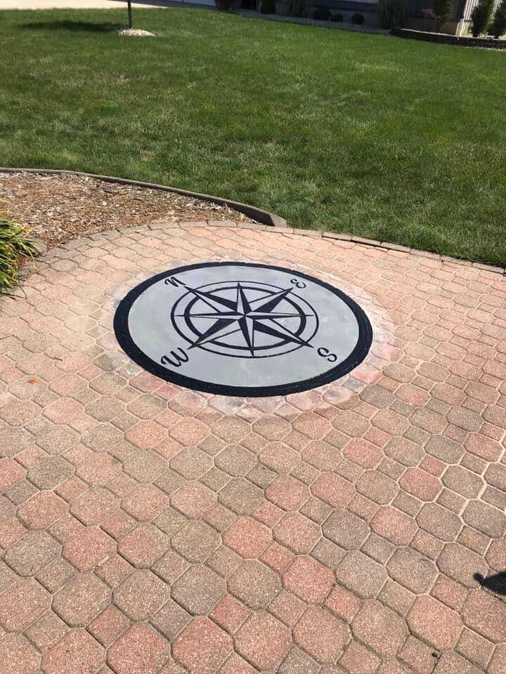 A compass is engraved on a brick walkway.