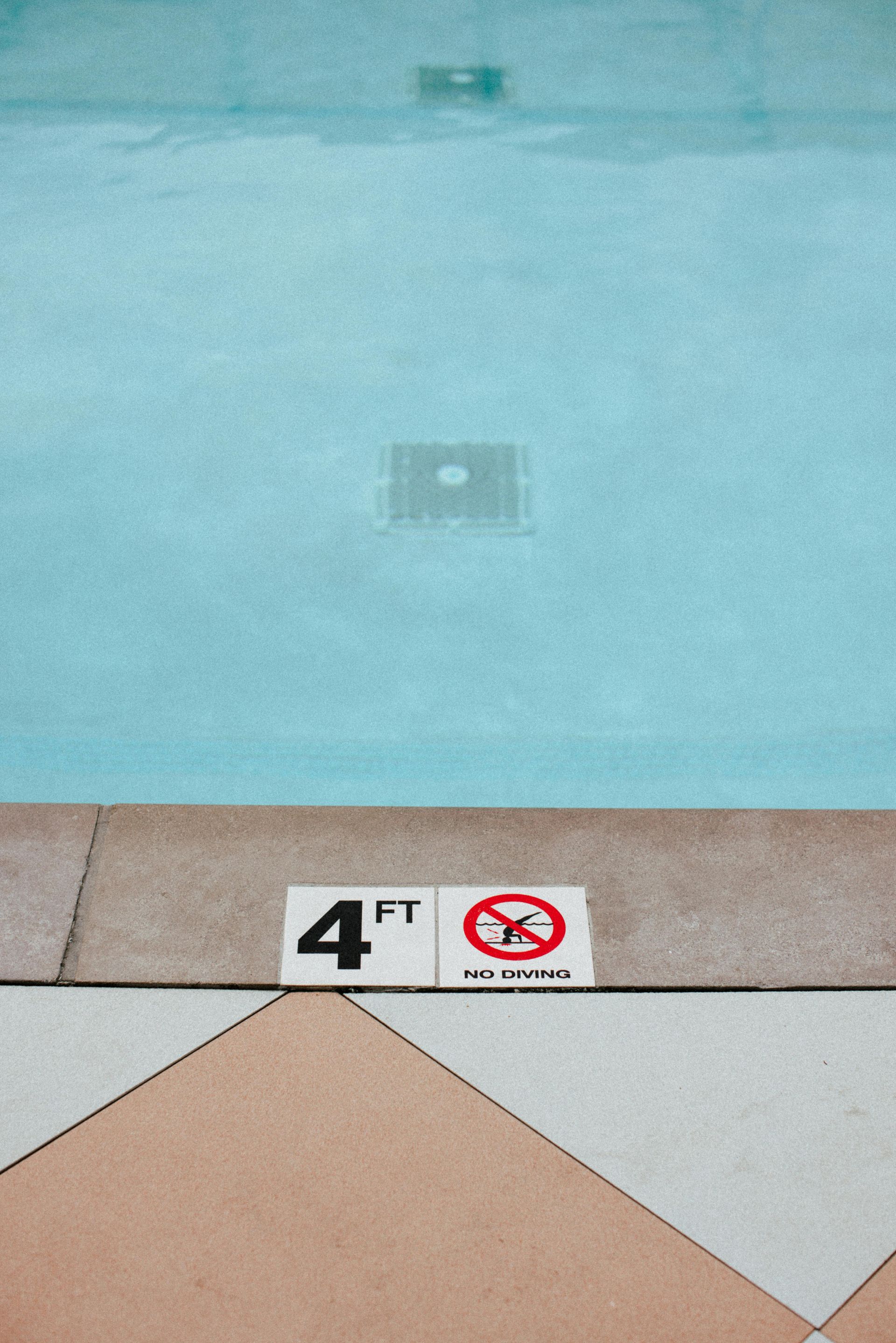 A pool table is sitting on a shiny concrete floor in a room.