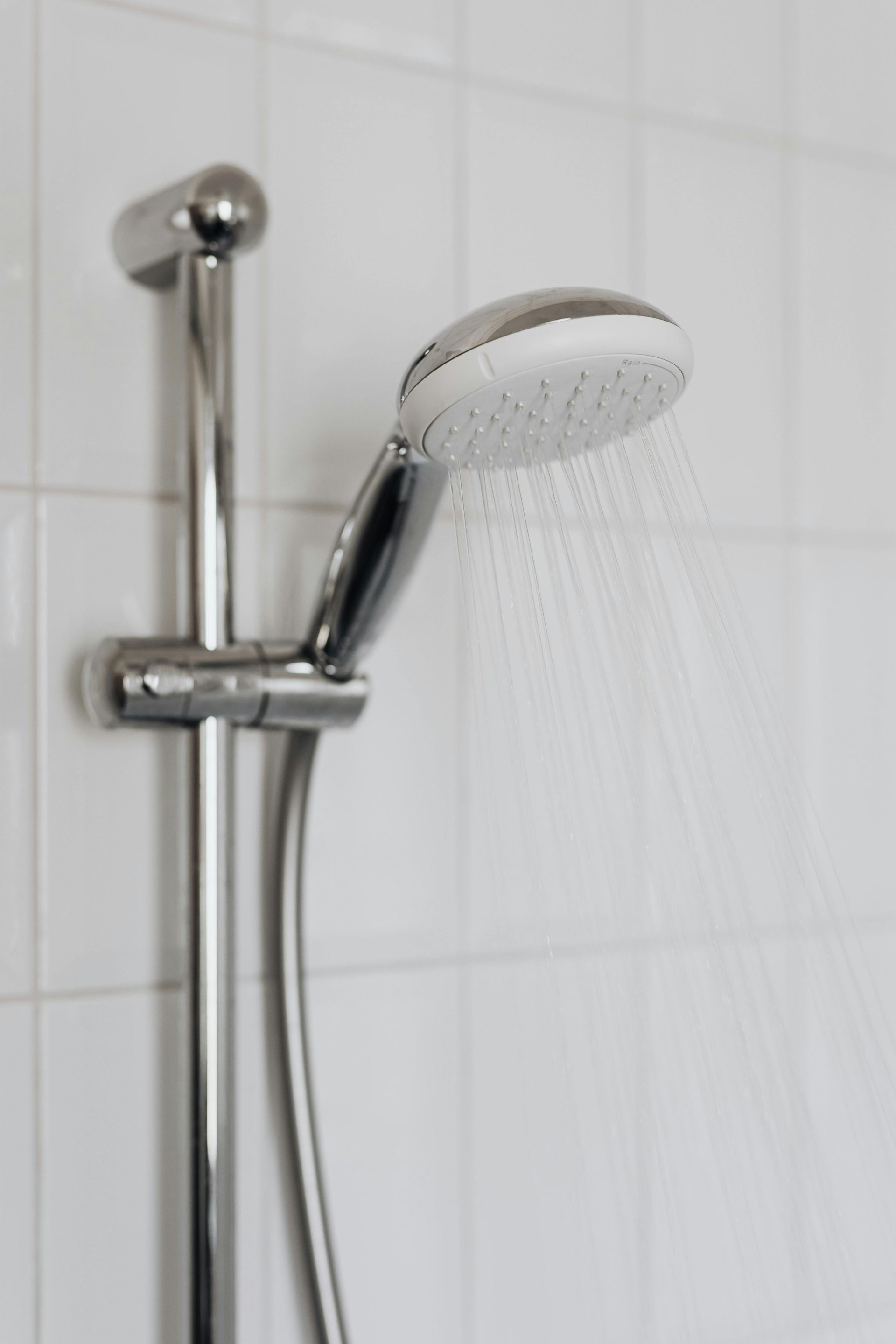 A close up of a shower head with water coming out of it.