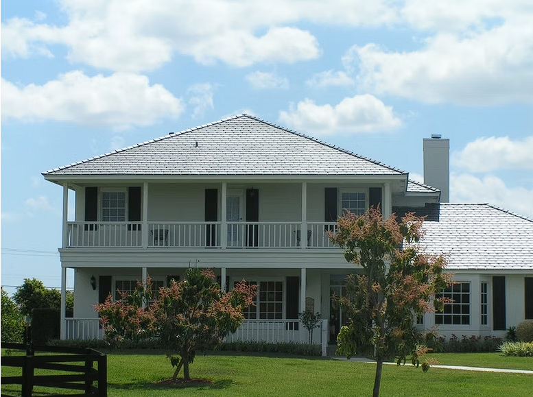 A large white house with a fence in front of it