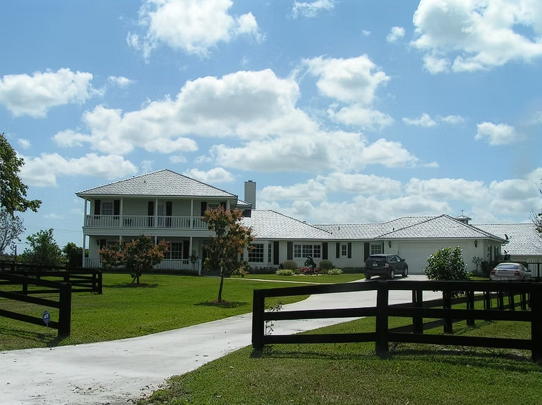 A large white house with a black fence in front of it