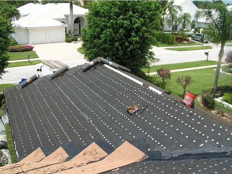 The roof of a house is being repaired with a roofing material