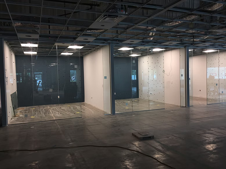 A large empty room with a lot of glass doors.