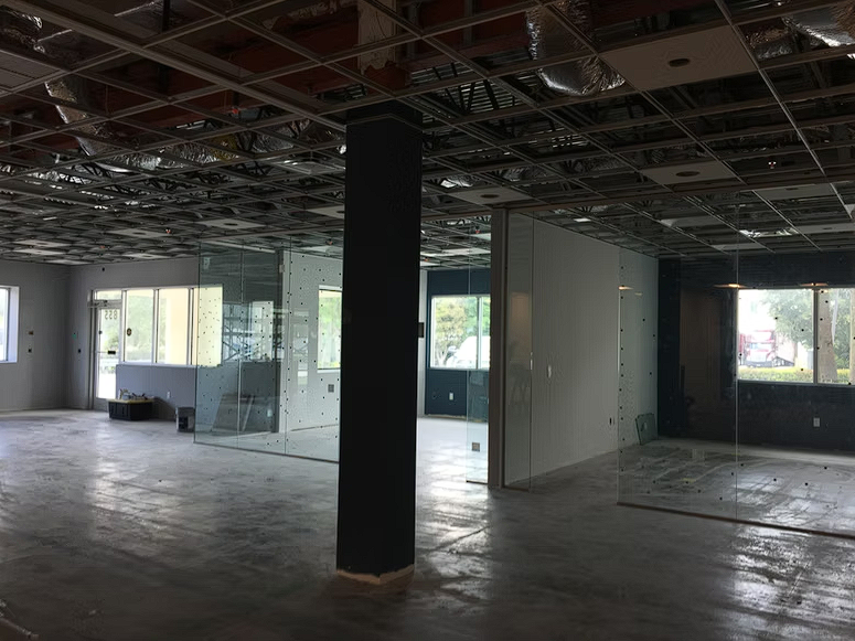 A large empty room with a black pillar in the middle.