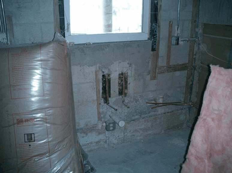 A room with a large bag of insulation and a window.