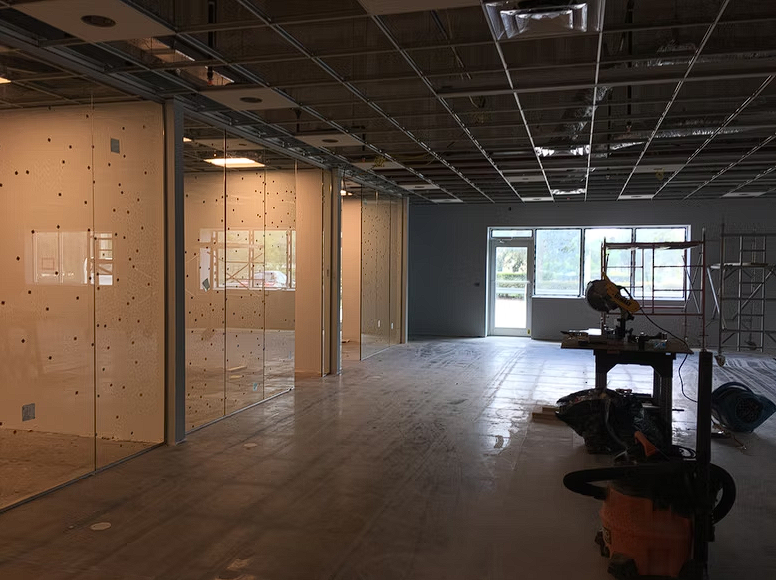 A large empty room with a vacuum cleaner on the floor.