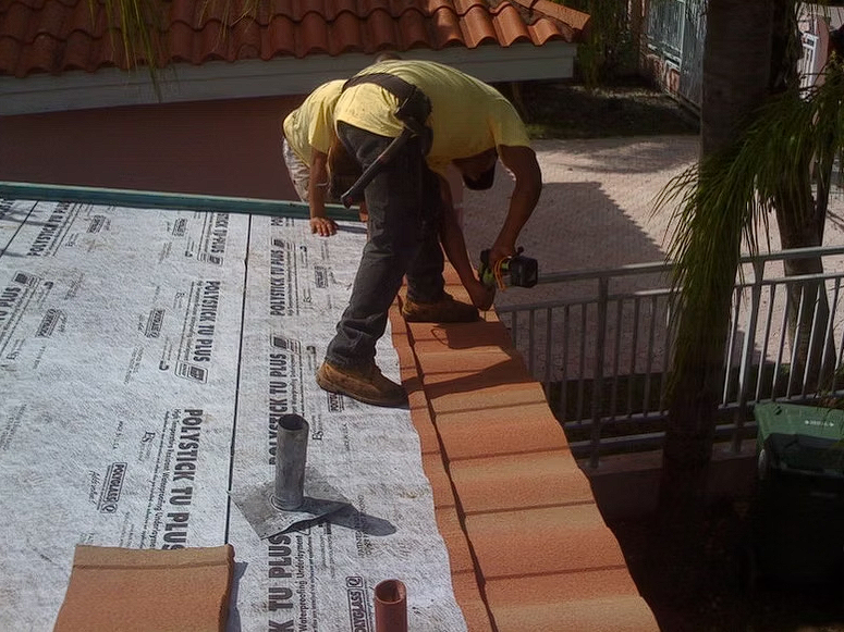 A man is working on a roof that says master to plus