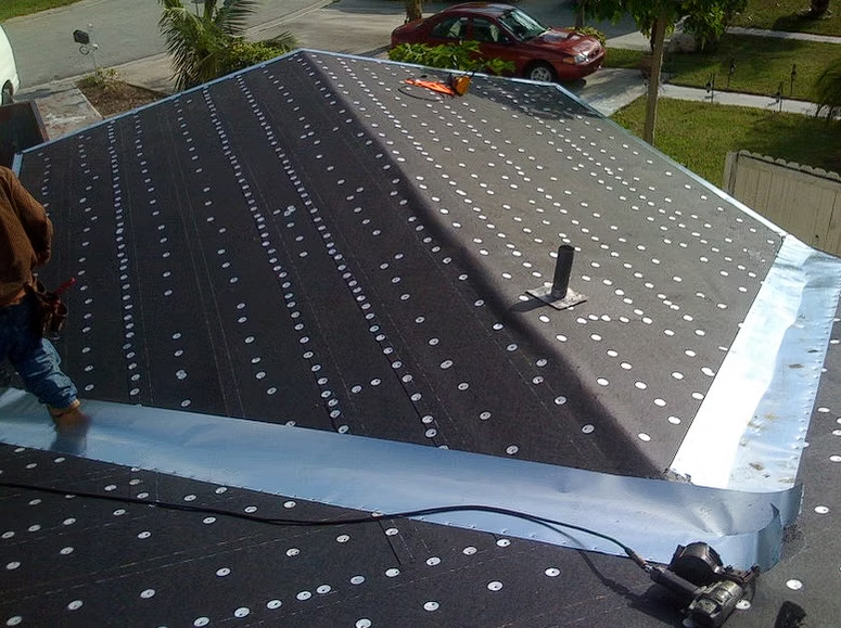A man is working on the roof of a house