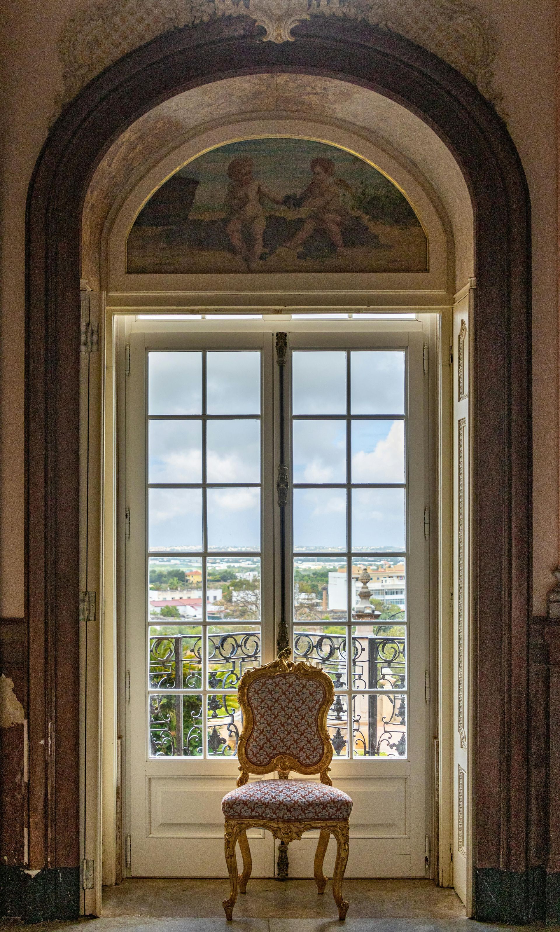 A chair is sitting in front of a window with a view of a city.