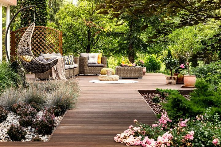 Feature wooden decking with chair swing and additional surrounding landscaping