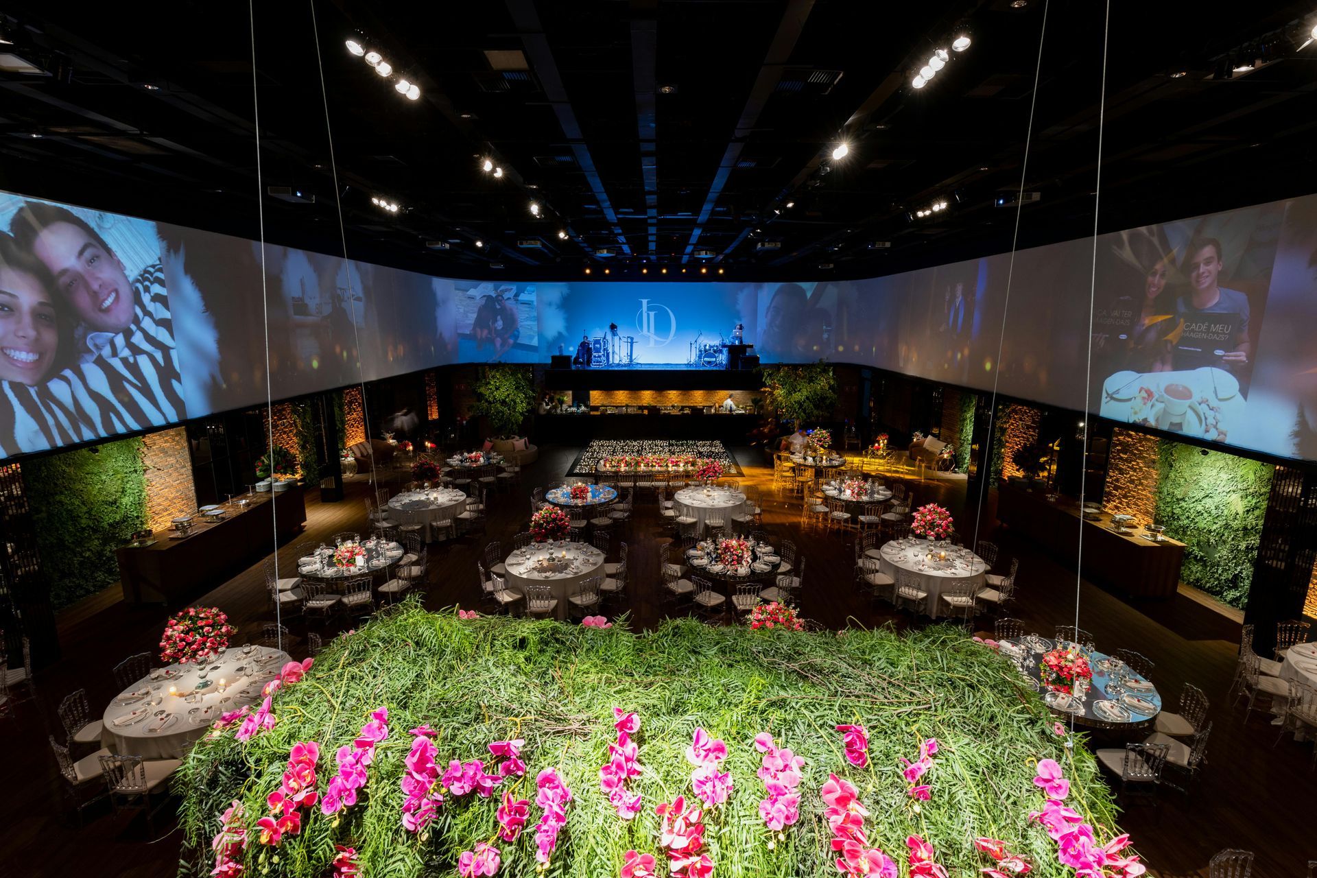 A large room filled with tables and chairs and a large screen.