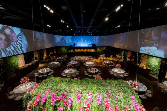 A large room filled with tables and chairs and a large screen.