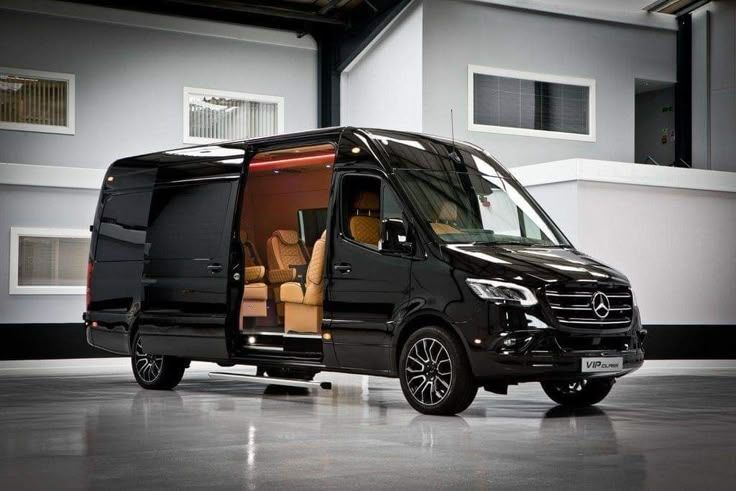 Black Mercedes van with open door, tan interior.