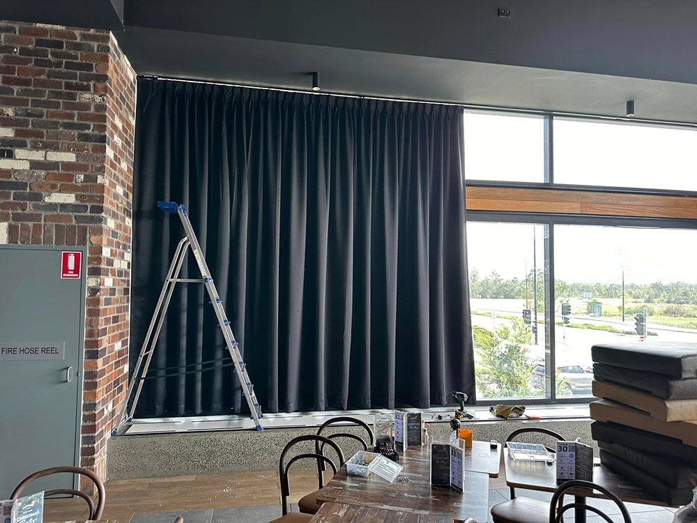 A Large Dining Room With Tables And Chairs And A Stage — Huntlee Blinds and Shutters in Badagarang, NSW