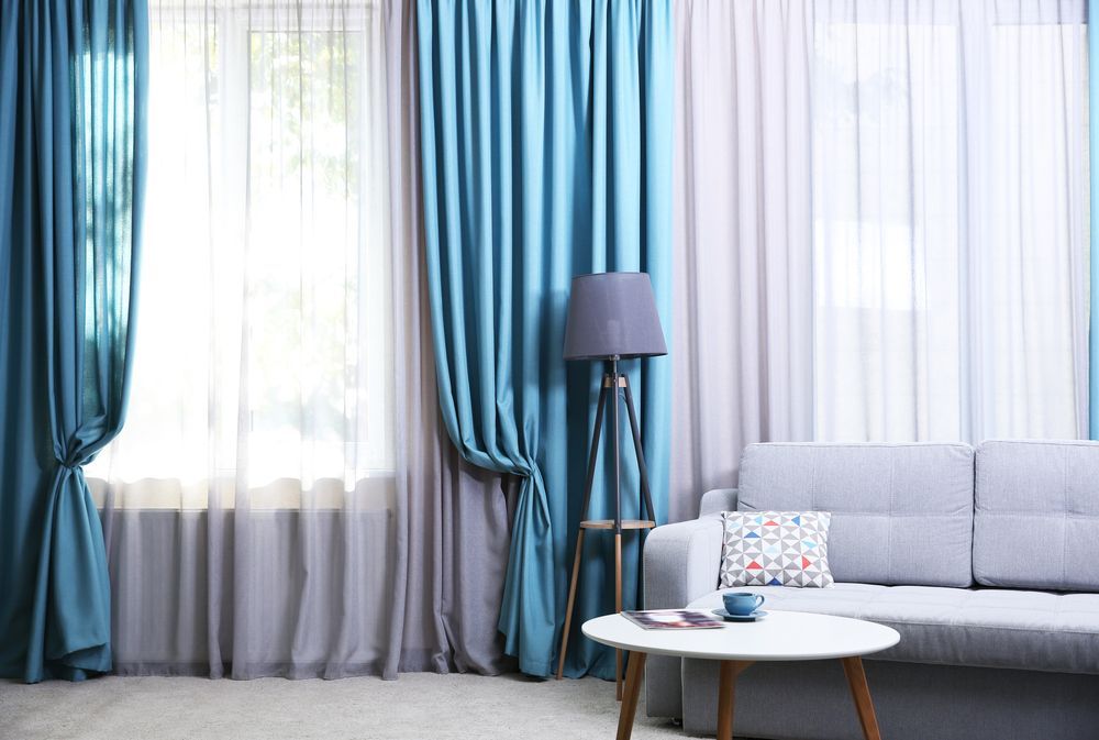 Living Room With Blue and White Curtains — Huntlee Blinds and Shutters in Badagarang, NSW