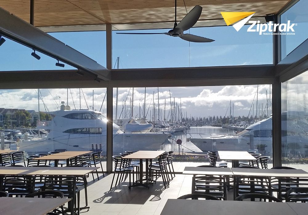 A restaurant with tables and chairs and a ceiling fan — Huntlee Blinds and Shutters in Badagarang, NSW