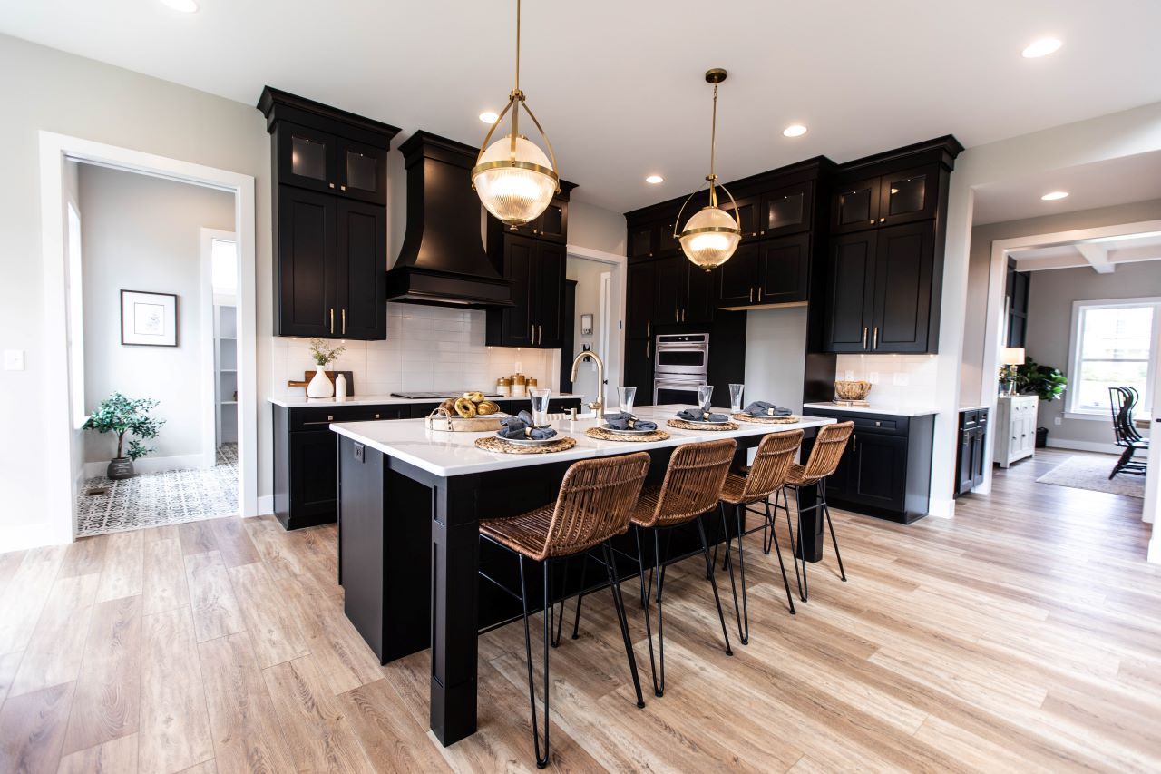 Kitchen featuring dark cabinets and gold accents in the cabinets and lighting