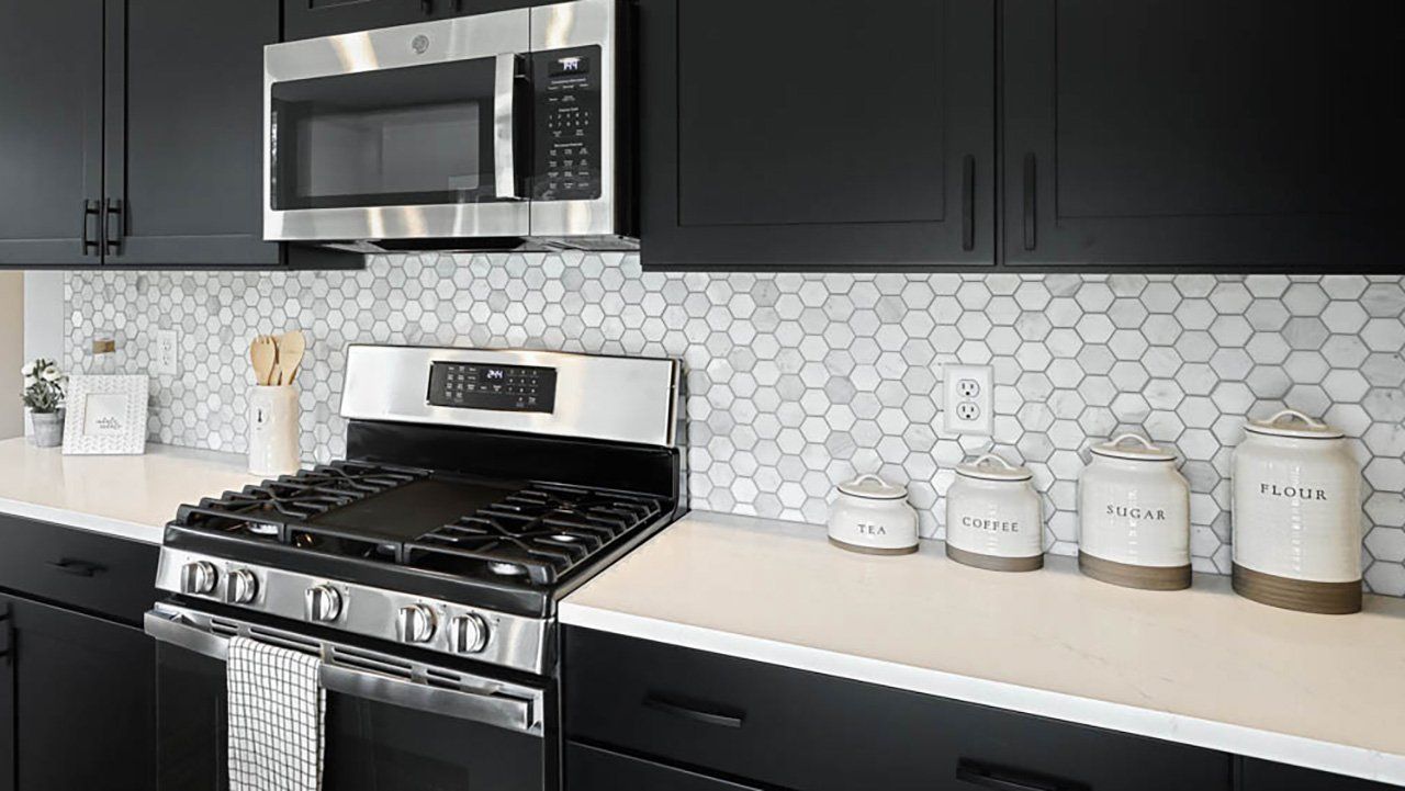 Brookfield model in the Creekside Meadows Community with black cabinets and grey and white honeycomb tile