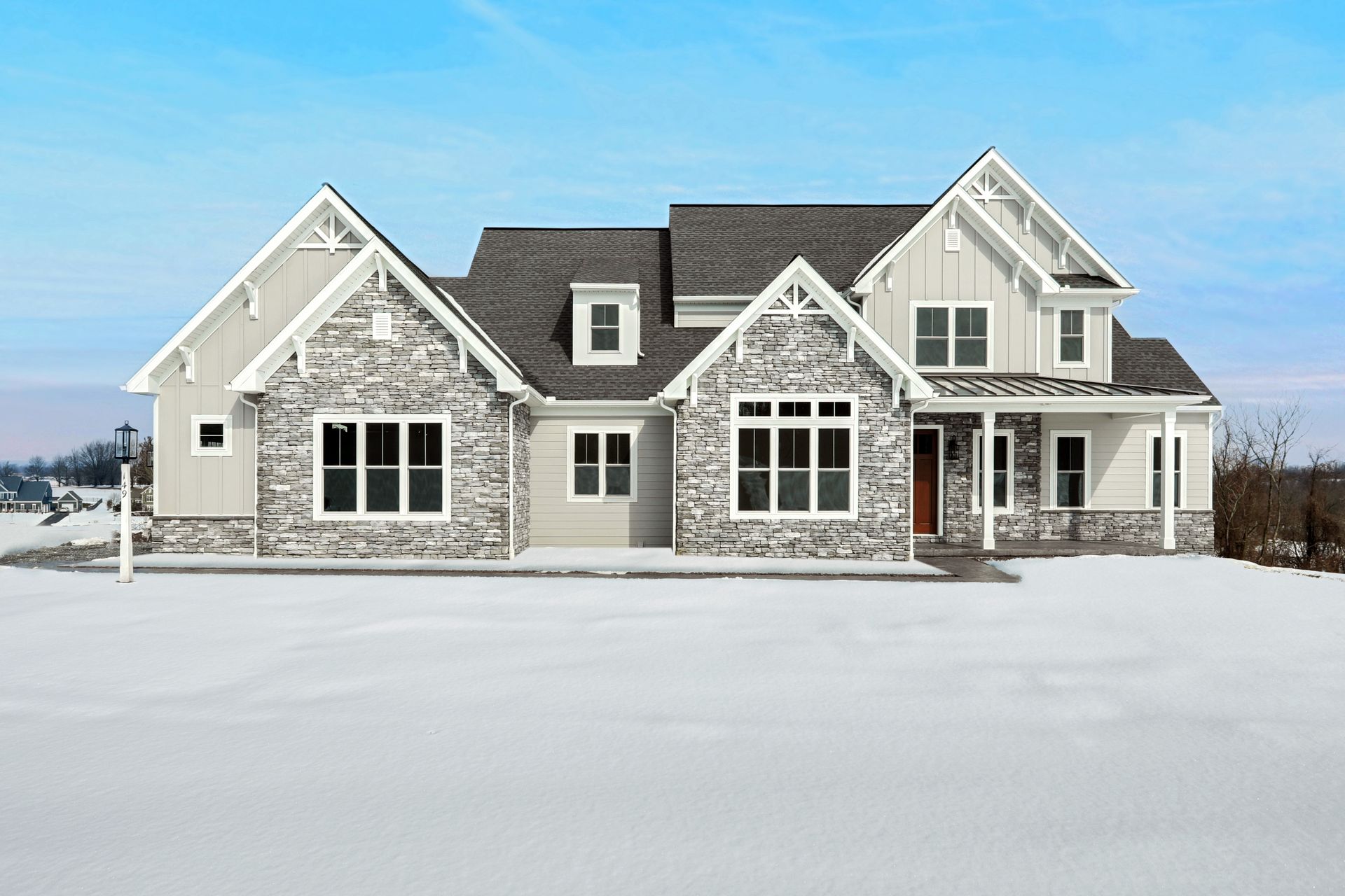 A large house is sitting in the middle of a snowy field.