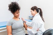 Doctor examining a patient’s arm in a clinic exam room