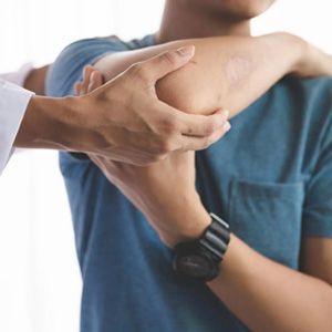 Person stretching an arm during a shoulder massage or physiotherapy session
