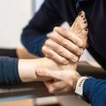 Hands holding and supporting a foot during a massage or therapy session