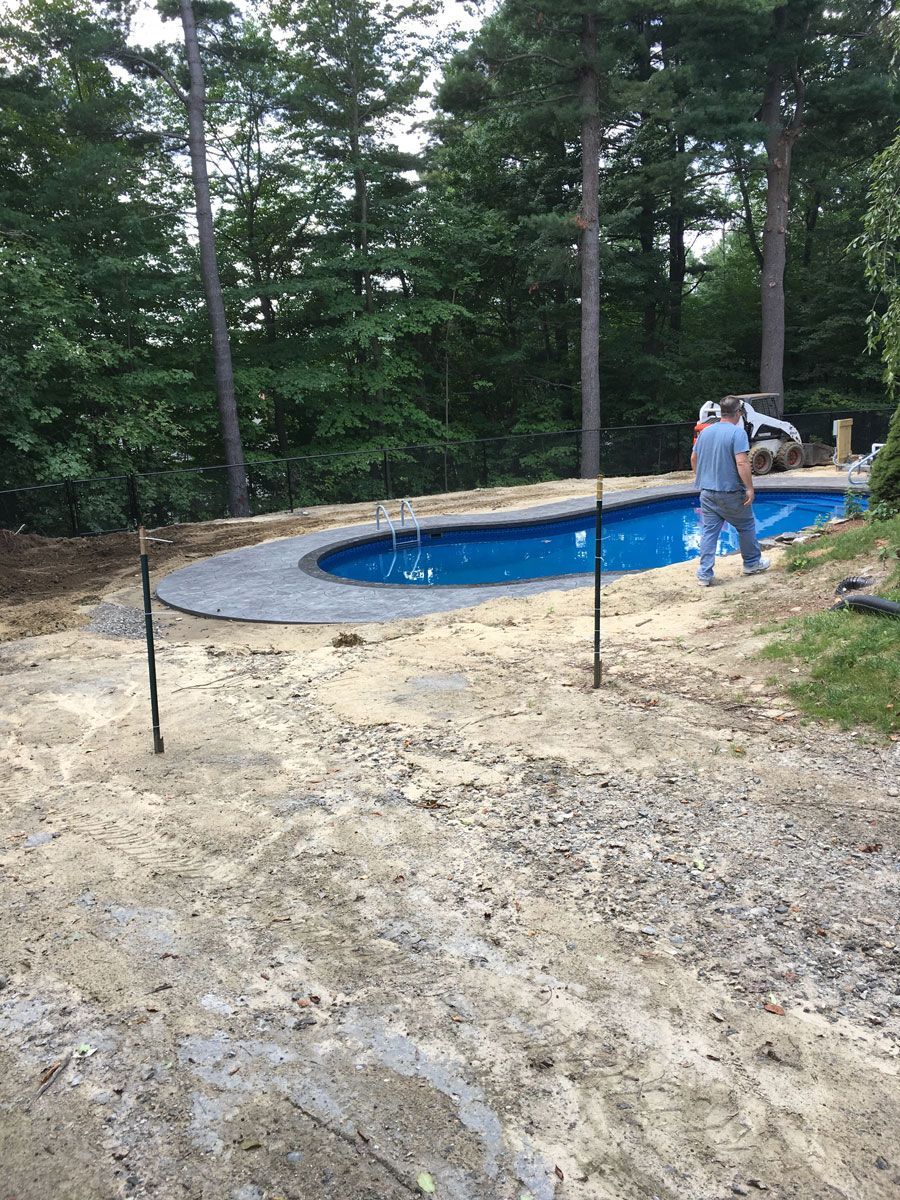 Man Standing In Front Of A Swimming Pool — Shrewsbury, MA — Maintenance Free Landscapes