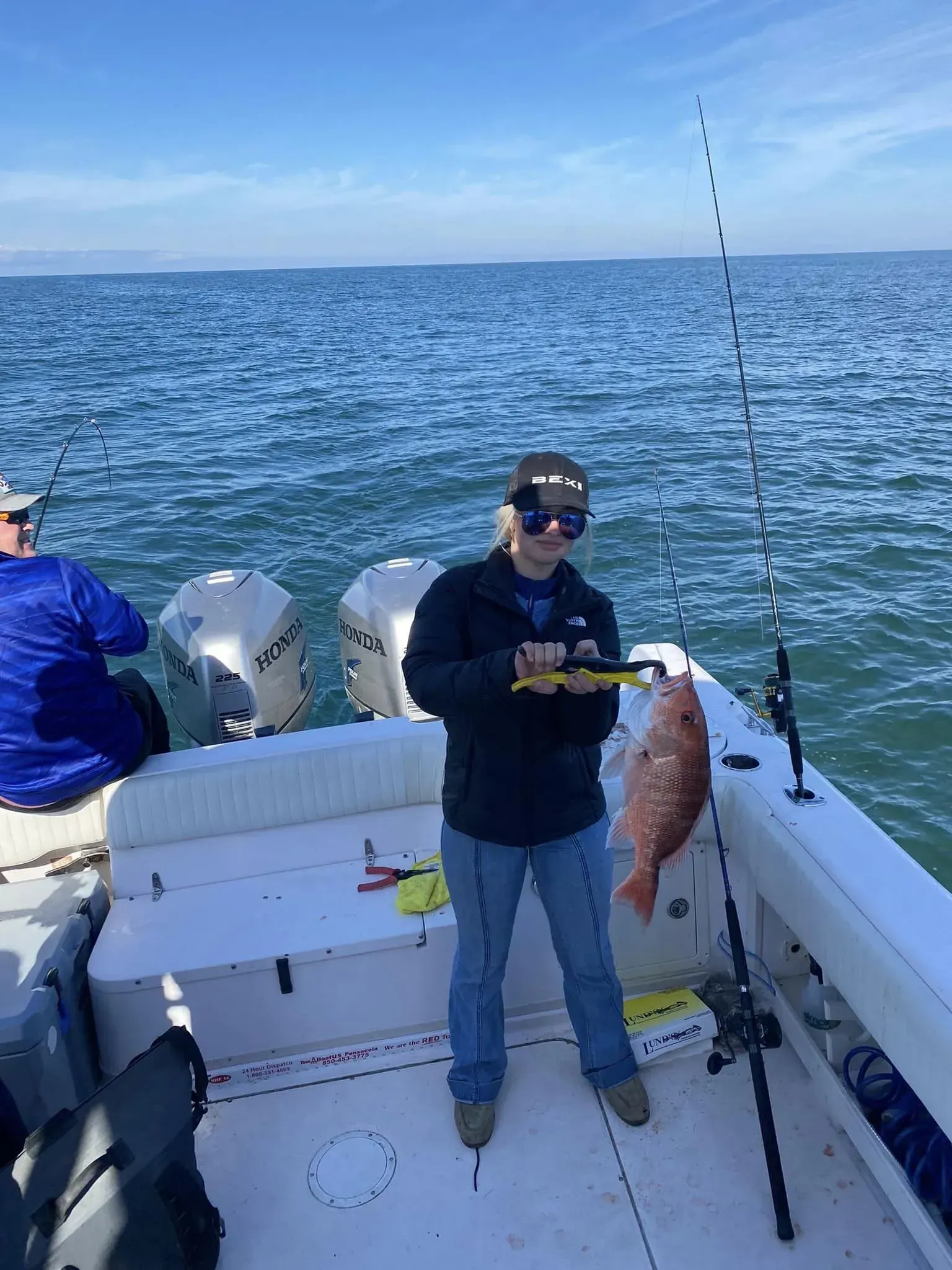 A man is standing on a boat holding a fish.